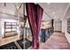 Sophisticated interior with a glass-enclosed space, hardwood floors, and elegant maroon curtains at 127 N Tryon St # 404, Charlotte, NC 28202
