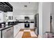 Contemporary kitchen featuring stainless steel appliances, white cabinets, black countertop, and hardwood floors at 127 N Tryon St # 404, Charlotte, NC 28202