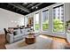 Stylish living room with hardwood floors, exposed beam ceiling, modern furnishings, and natural light at 127 N Tryon St # 404, Charlotte, NC 28202