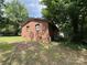 Exterior shot showing brick facade with windows and landscaped yard surrounded by mature trees at 13134 Homewood Dr, Charlotte, NC 28262