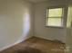 Cozy bedroom featuring carpet flooring, window, and access to a closet at 13134 Homewood Dr, Charlotte, NC 28262