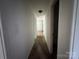 Narrow hallway with carpeted floor, white walls and neutral trim, illuminated by an overhead light at 13134 Homewood Dr, Charlotte, NC 28262