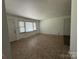 Vacant living room with tile flooring and natural light from large window, adjacent to an entry door at 13134 Homewood Dr, Charlotte, NC 28262