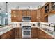 Close-up of kitchen features stainless steel stove, microwave, and wood cabinets at 1328 Somersby Cir, Gastonia, NC 28054