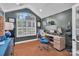 Home office featuring vaulted ceiling, modern desk, large window with plantation shutters, and sleek dark green walls at 1328 Somersby Cir, Gastonia, NC 28054