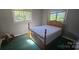 Cozy bedroom features vintage wood bed frame, two windows, and great natural light at 133 Pine State Rd, Troutman, NC 28166