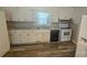 Well-lit kitchen with white cabinets, modern appliances, and a breakfast bar on a wood-look floor at 133 Pine State Rd, Troutman, NC 28166