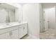 Well-lit bathroom with a double sink vanity, white cabinetry and a walk-in shower at 1421 Wildflower St, Newton, NC 28658