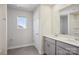Well-lit bathroom featuring a double sink vanity, gray cabinets, a large mirror, and tiled floors at 145 Satchel Ct, Mooresville, NC 28115
