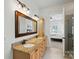Luxurious bathroom with dual sinks, granite counters, and a view into the bright bedroom at 15714 Laurel Oak Cres, Davidson, NC 28036