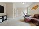 Bright bonus room with plush carpet, leather couch, and stationary bike at 15714 Laurel Oak Cres, Davidson, NC 28036