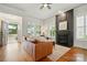 Bright living room with a fireplace, hardwood floors, and abundant natural light through shuttered windows at 15714 Laurel Oak Cres, Davidson, NC 28036