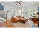 Bright living room with a fireplace, hardwood floors, and abundant natural light through shuttered windows at 15714 Laurel Oak Cres, Davidson, NC 28036