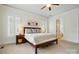 Well-lit primary bedroom with a ceiling fan, three windows, and an en-suite bathroom at 15714 Laurel Oak Cres, Davidson, NC 28036