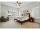 Spacious primary bedroom with a ceiling fan, ample natural light, and comfortable seating area at 15714 Laurel Oak Cres, Davidson, NC 28036