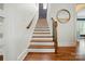 Staircase showcasing hardwood treads, a decorative wood railing, and neutral walls, connecting different levels of the home at 15714 Laurel Oak Cres, Davidson, NC 28036
