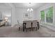 Elegant dining room featuring a modern chandelier, large window, and seating for six at 15831 Breton Brook St, Huntersville, NC 28078