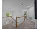 Bright and airy hallway featuring a wooden banister and large window, leading to other rooms at 15831 Breton Brook St, Huntersville, NC 28078