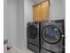 Modern laundry room featuring LG washer and dryer on pedestals, plus overhead cabinet at 15831 Breton Brook St, Huntersville, NC 28078