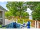 Back porch overlooks a lake surrounded by lush greenery, with blue patio furniture at 18028 Broken Woods Rd, Charlotte, NC 28278