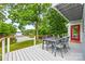 Back porch with a table set overlooks a lake surrounded by greenery at 18028 Broken Woods Rd, Charlotte, NC 28278
