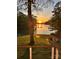 Backyard patio with firepit and seating at sunset overlooking the lake at 18028 Broken Woods Rd, Charlotte, NC 28278