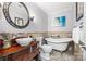 Charming bathroom featuring a clawfoot tub, decorative vanity, and classic fixtures at 18028 Broken Woods Rd, Charlotte, NC 28278