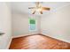 Bright bedroom with hardwood floors, ceiling fan, and a window with natural light at 18028 Broken Woods Rd, Charlotte, NC 28278