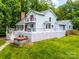Expansive deck with hot tub wraps around this light blue home nestled among mature trees at 18028 Broken Woods Rd, Charlotte, NC 28278