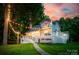 Lake house featuring a spacious deck, hot tub, balcony, and string lights creating a cozy outdoor ambiance at sunset at 18028 Broken Woods Rd, Charlotte, NC 28278