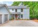 Two-story home featuring a quaint front porch, gray siding, and an attached two-car garage, enhancing curb appeal at 18028 Broken Woods Rd, Charlotte, NC 28278