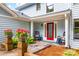 Charming front porch showcasing colorful flower pots and rocking chairs, adding a touch of Southern comfort to the entrance at 18028 Broken Woods Rd, Charlotte, NC 28278