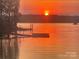 Sunset view over the lake with docks in the distance at 18028 Broken Woods Rd, Charlotte, NC 28278