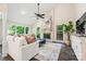Bright living room with a stone fireplace, large windows, and stylish furnishings, creating a cozy gathering space at 18028 Broken Woods Rd, Charlotte, NC 28278