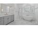Modern bathroom with gray vanity, soaking tub, glass shower and brushed gold hardware at 18705 Harbor Light Blvd, Cornelius, NC 28031