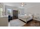 Charming bedroom with a white bed frame, wood floors, and natural light from large windows at 18705 Harbor Light Blvd, Cornelius, NC 28031