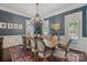 Stylish dining room with blue textured wallpaper, a large chandelier, and a rustic wooden table at 18705 Harbor Light Blvd, Cornelius, NC 28031