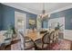 Stylish dining room with blue textured wallpaper, a large chandelier, and a rustic wooden table at 18705 Harbor Light Blvd, Cornelius, NC 28031