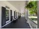 Spacious front porch with rocking chairs, French doors, and decorative hanging plants at 18705 Harbor Light Blvd, Cornelius, NC 28031