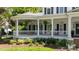 Inviting wraparound porch with white columns, railings, and lush landscaping at 18705 Harbor Light Blvd, Cornelius, NC 28031