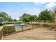 Relaxing backyard scene with a wooden deck, inground pool, and lush landscaping at 188 Turnberry Ln, Mooresville, NC 28117