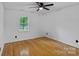 Sunlit bedroom with hardwood floors, window, and ceiling fan at 188 Turnberry Ln, Mooresville, NC 28117