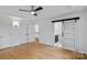 Bright bedroom with a ceiling fan and a sliding barn door which leads to the ensuite bathroom at 188 Turnberry Ln, Mooresville, NC 28117