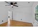 Bright bedroom features hardwood floors, window, ceiling fan, and a door to the bathroom at 188 Turnberry Ln, Mooresville, NC 28117