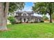 Charming two-story home with a manicured front lawn, mature trees, and a welcoming porch at 188 Turnberry Ln, Mooresville, NC 28117