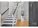 Bright foyer with hardwood floors, stairs, and a view of a dining area through an open door at 188 Turnberry Ln, Mooresville, NC 28117
