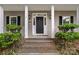 Charming home's front entrance featuring a black door, sidelights, and manicured landscaping at 188 Turnberry Ln, Mooresville, NC 28117