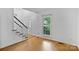 Hallway with hardwood floors, white walls and a staircase with white railings and black handrail at 188 Turnberry Ln, Mooresville, NC 28117