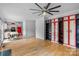 Open-concept living area with wood floors, ceiling fan, view into the kitchen, and custom shelving at 188 Turnberry Ln, Mooresville, NC 28117