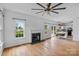 Bright living room featuring a fireplace, wood floors, and an open layout with a view into the kitchen at 188 Turnberry Ln, Mooresville, NC 28117